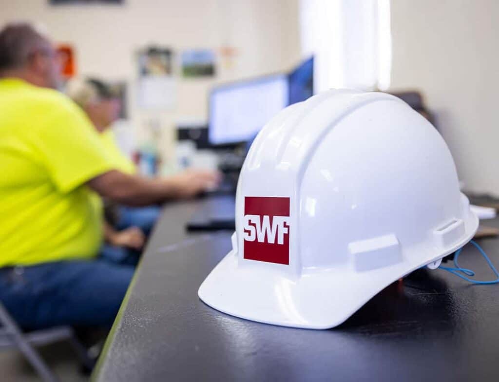 SWF Industrial project managers preparing for a structural steel fabrication project with a hardhat on the table.