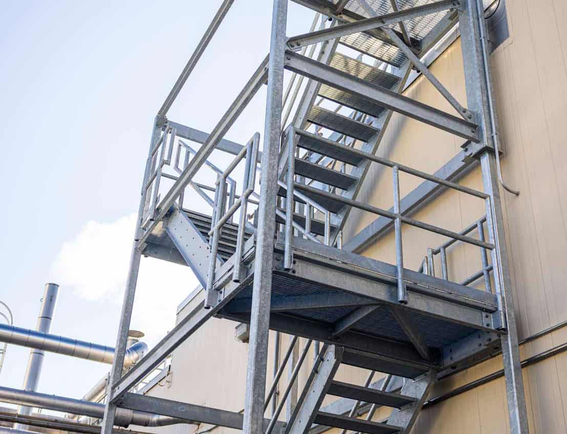 a steel staircase leading to the roof of a manufacturing facility